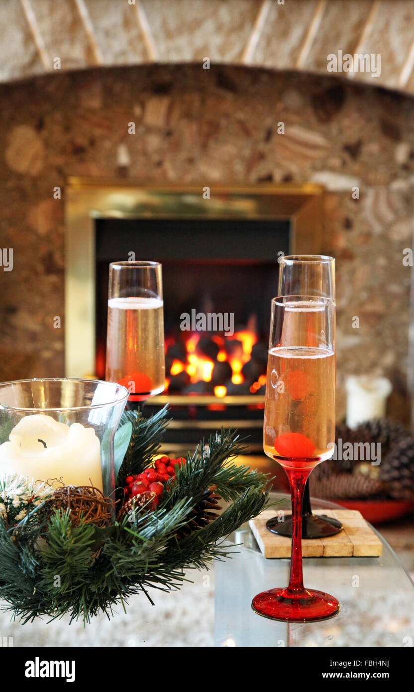Bebidas festivas en Navidad frente a un verdadero fuego Foto de stock