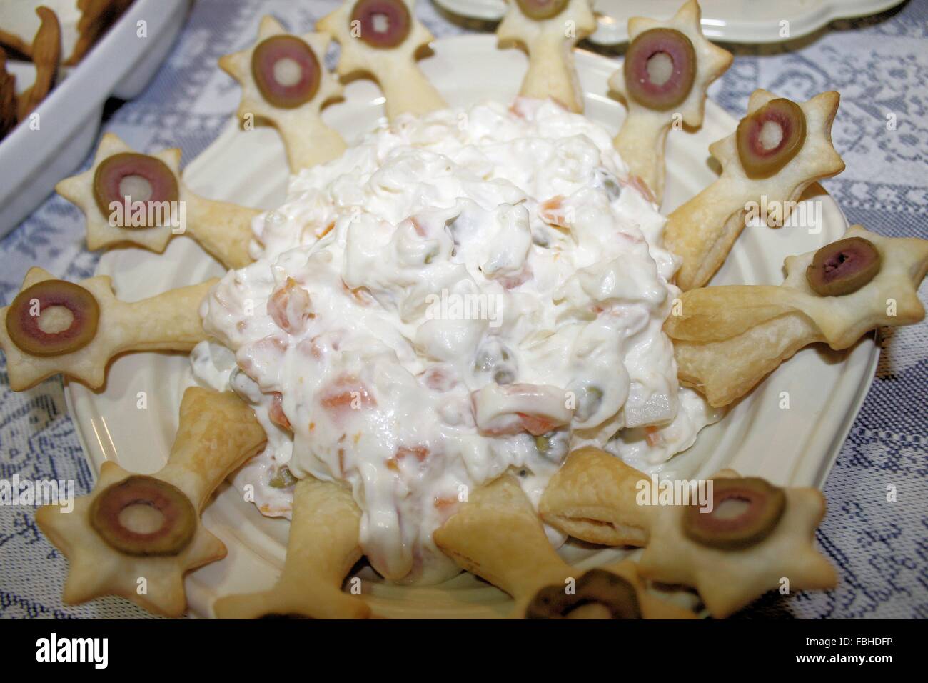 Plato con cuchara de hojaldre y ensalada rusa Foto de stock