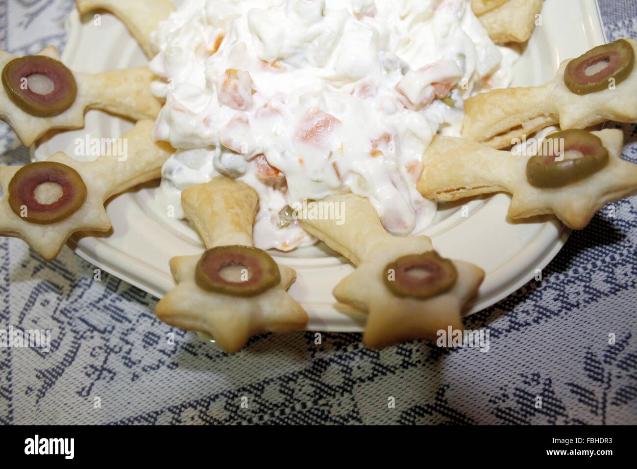 Plato con cuchara de hojaldre y ensalada rusa Foto de stock