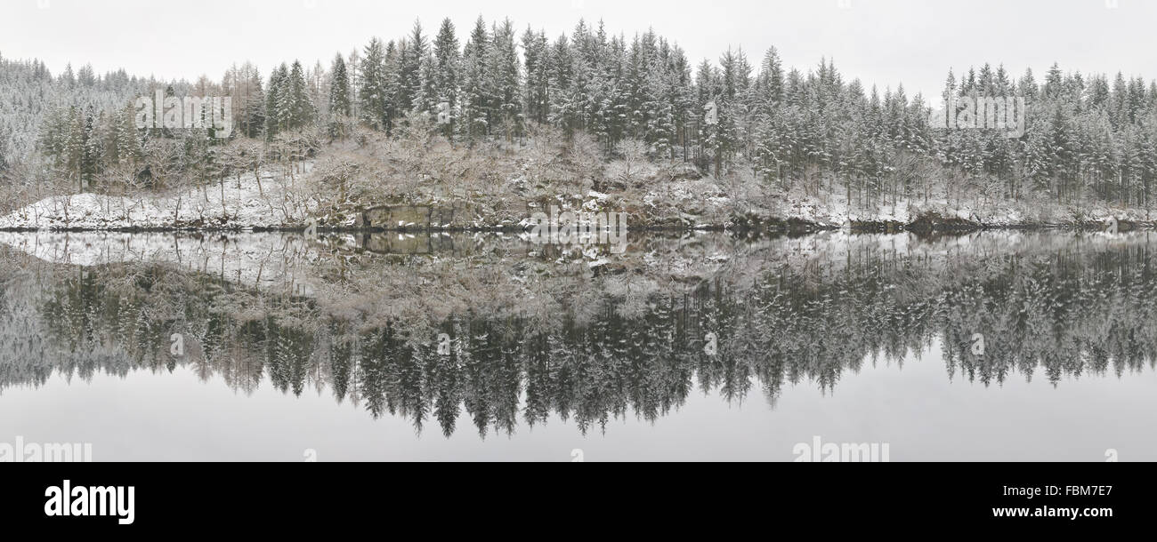 Loch Ard invierno reflexiones panorama - una luz copo de nieve y agua creando reflejos sorprendentemente detalladas Foto de stock