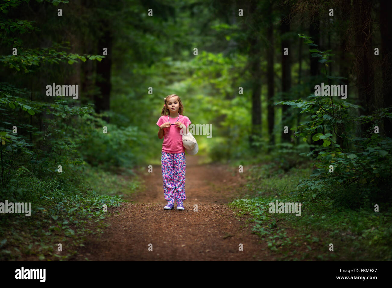 Chica parado en el sendero del bosque Foto de stock