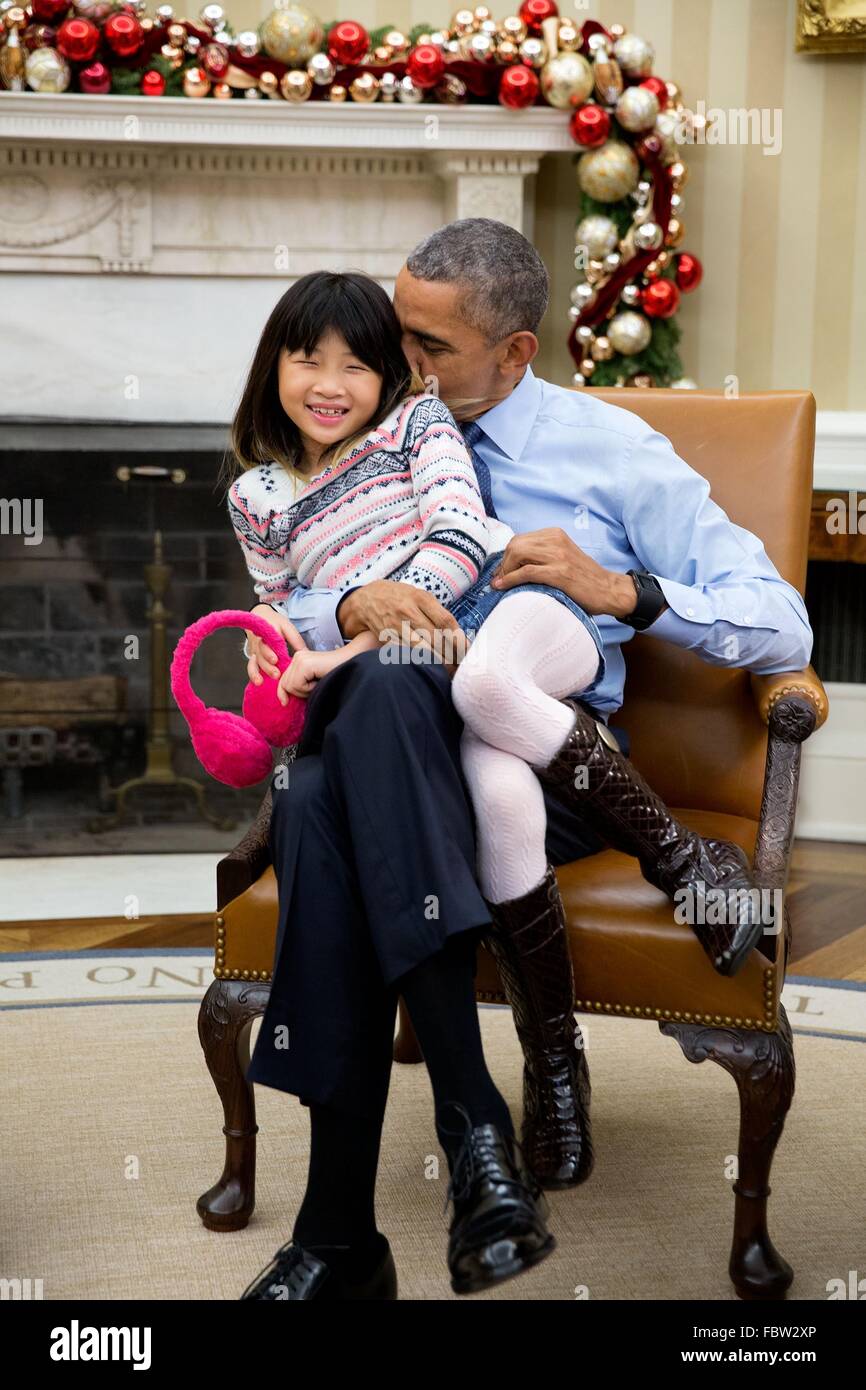 El presidente estadounidense Barack Obama snuggles con su sobrina Savita Ng después de su hermana, Maya Soetoro-Ng, y su familia cayó en la Oficina Oval de la Casa Blanca el 4 de diciembre de 2015 en Washington, DC. Foto de stock