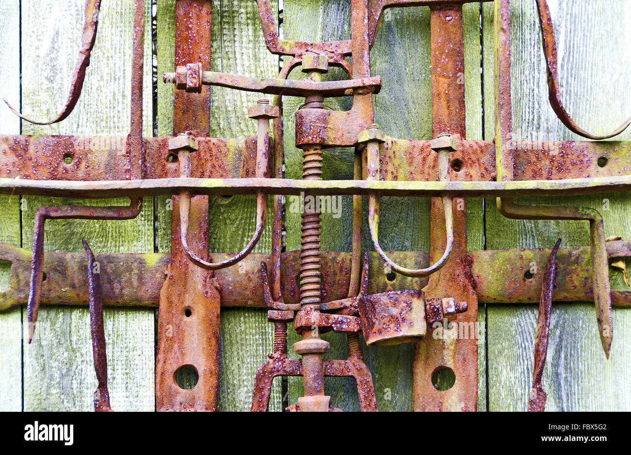 Maquinaria de hierro oxidado en viejas paredes de madera Foto de stock