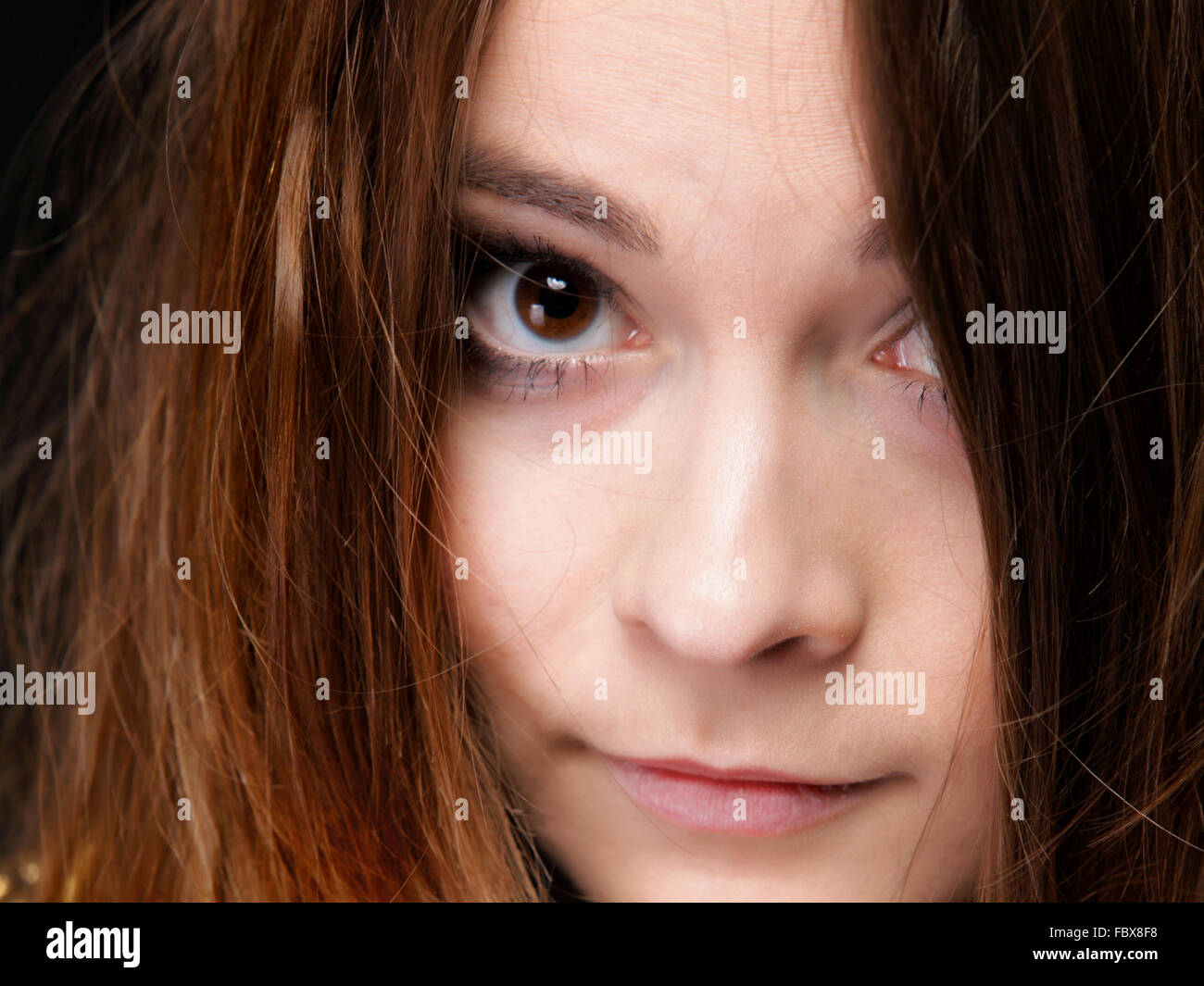 Closeup mujer cubre el rostro por largos pelos marrones Foto de stock