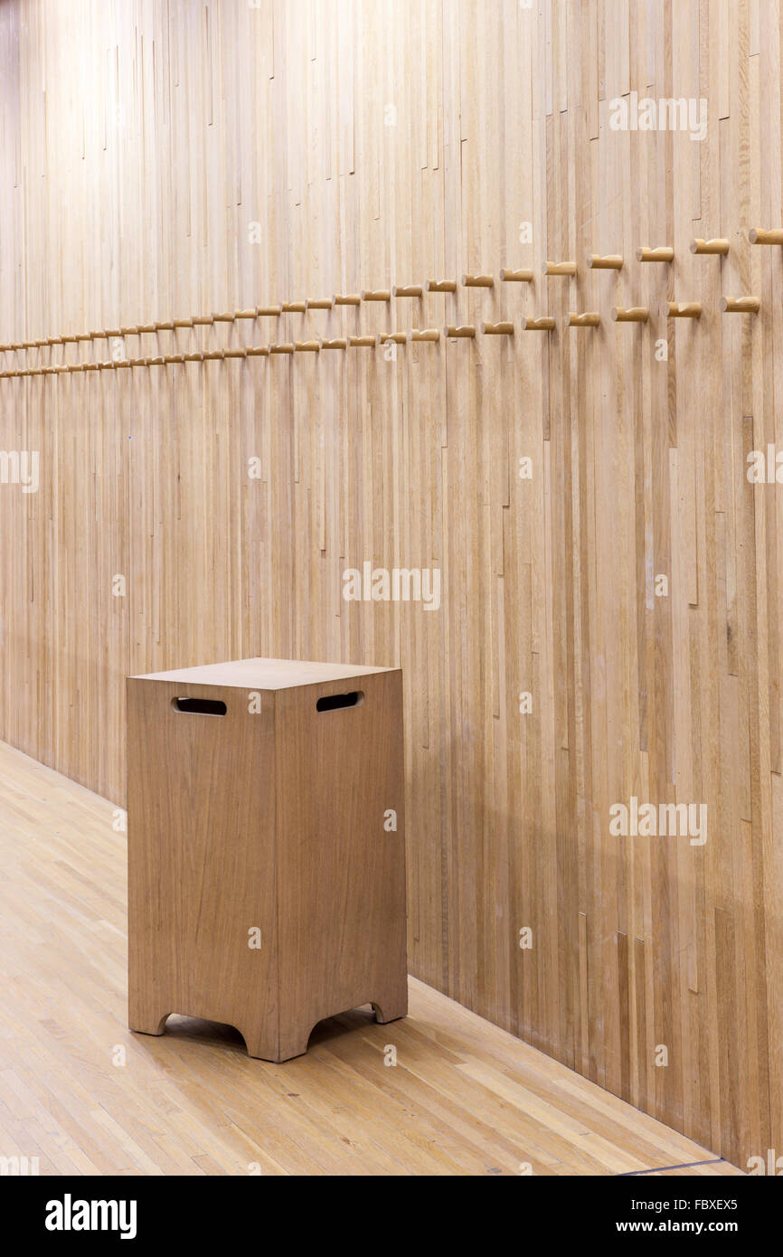 Una pared de madera con algunos perchero de madera y silla de madera Foto de stock