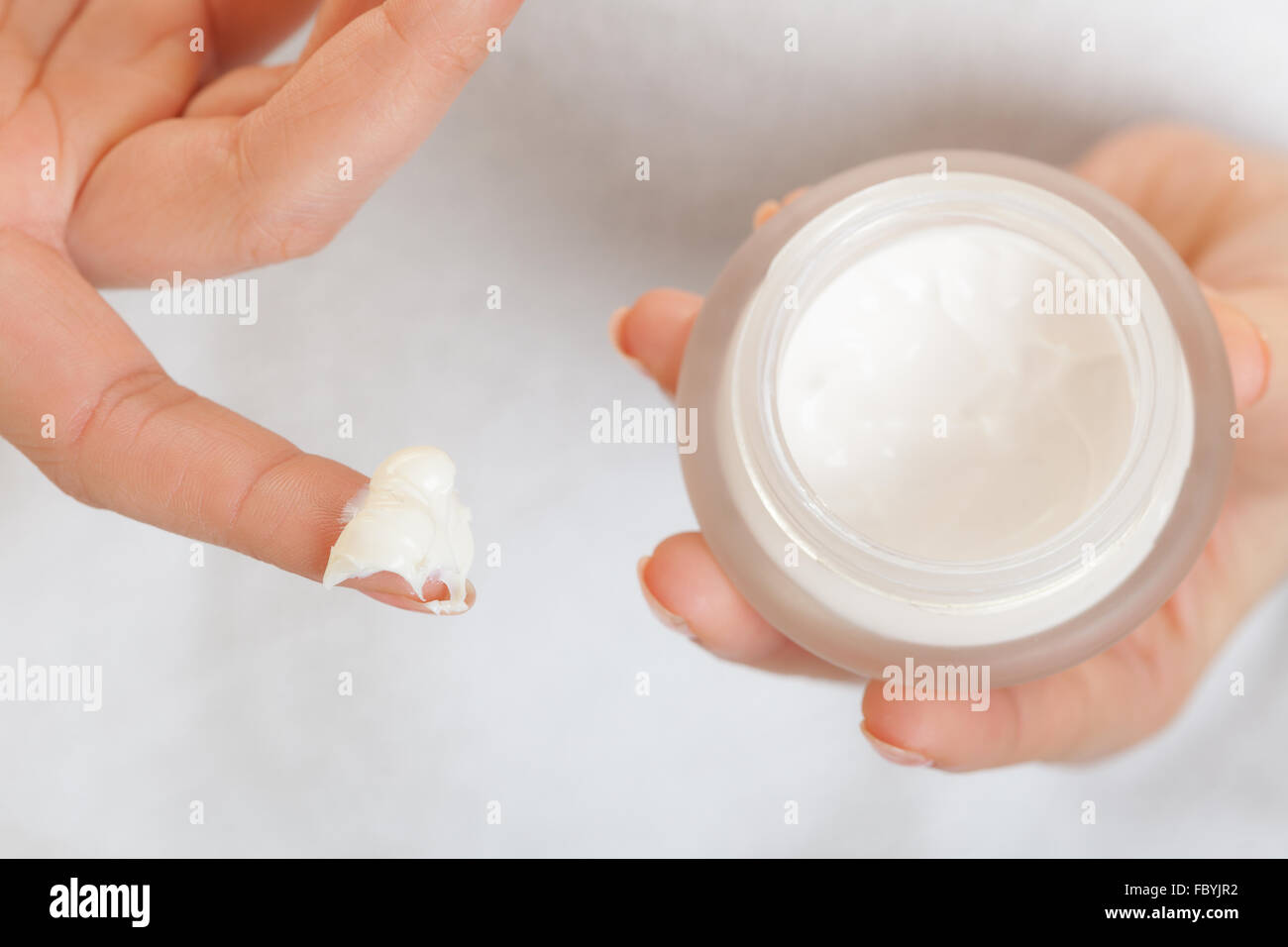 Cuidado de la piel. Chica aplicar crema hidratante. Foto de stock