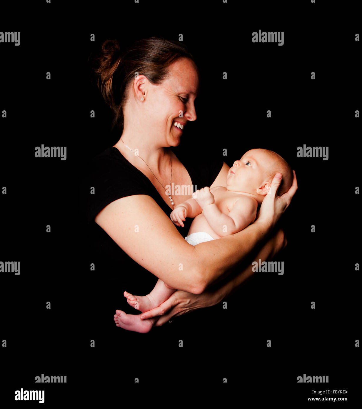 Feliz a la madre y al bebé lactante Foto de stock