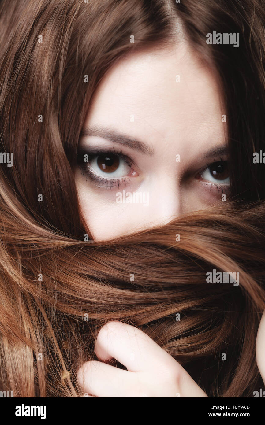 Mujer cubre el rostro por largos pelos marrones Foto de stock
