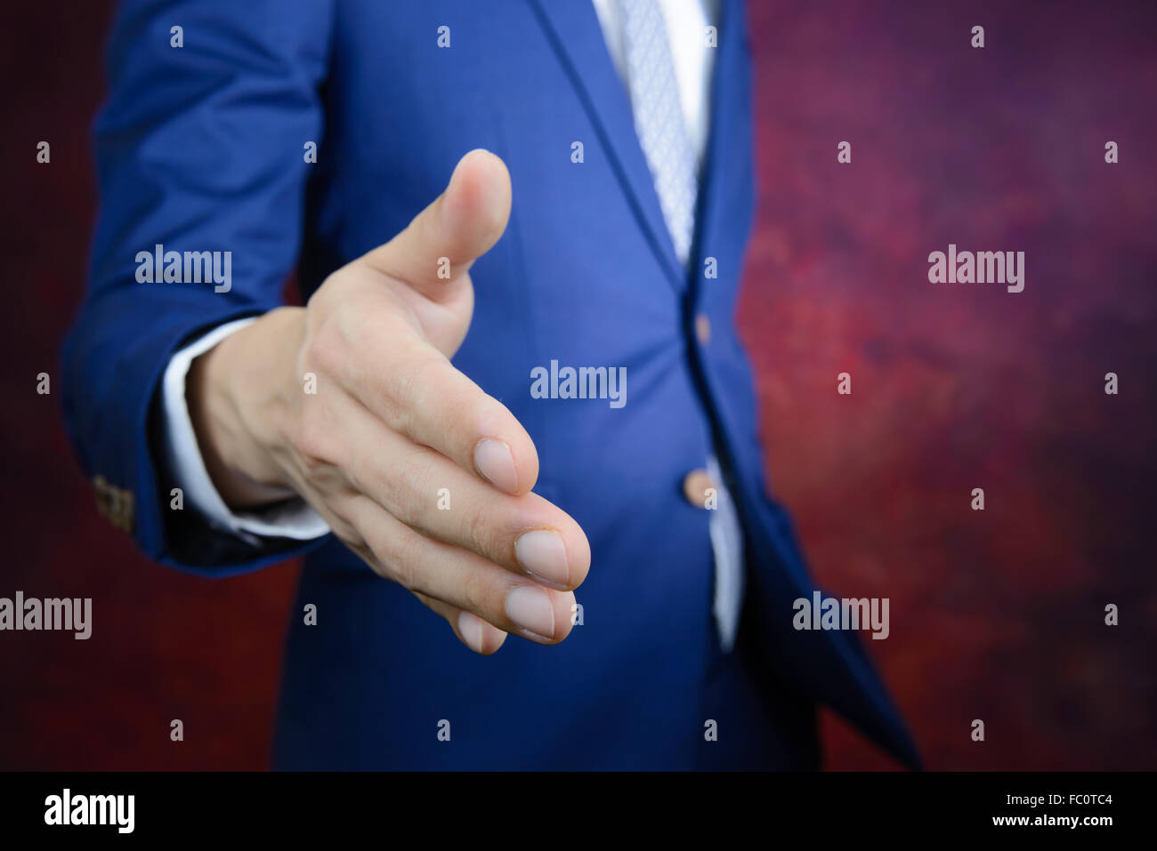 Empresario de traje azul llegando a mano para agitar las manos, hacer un negocio concepto Foto de stock