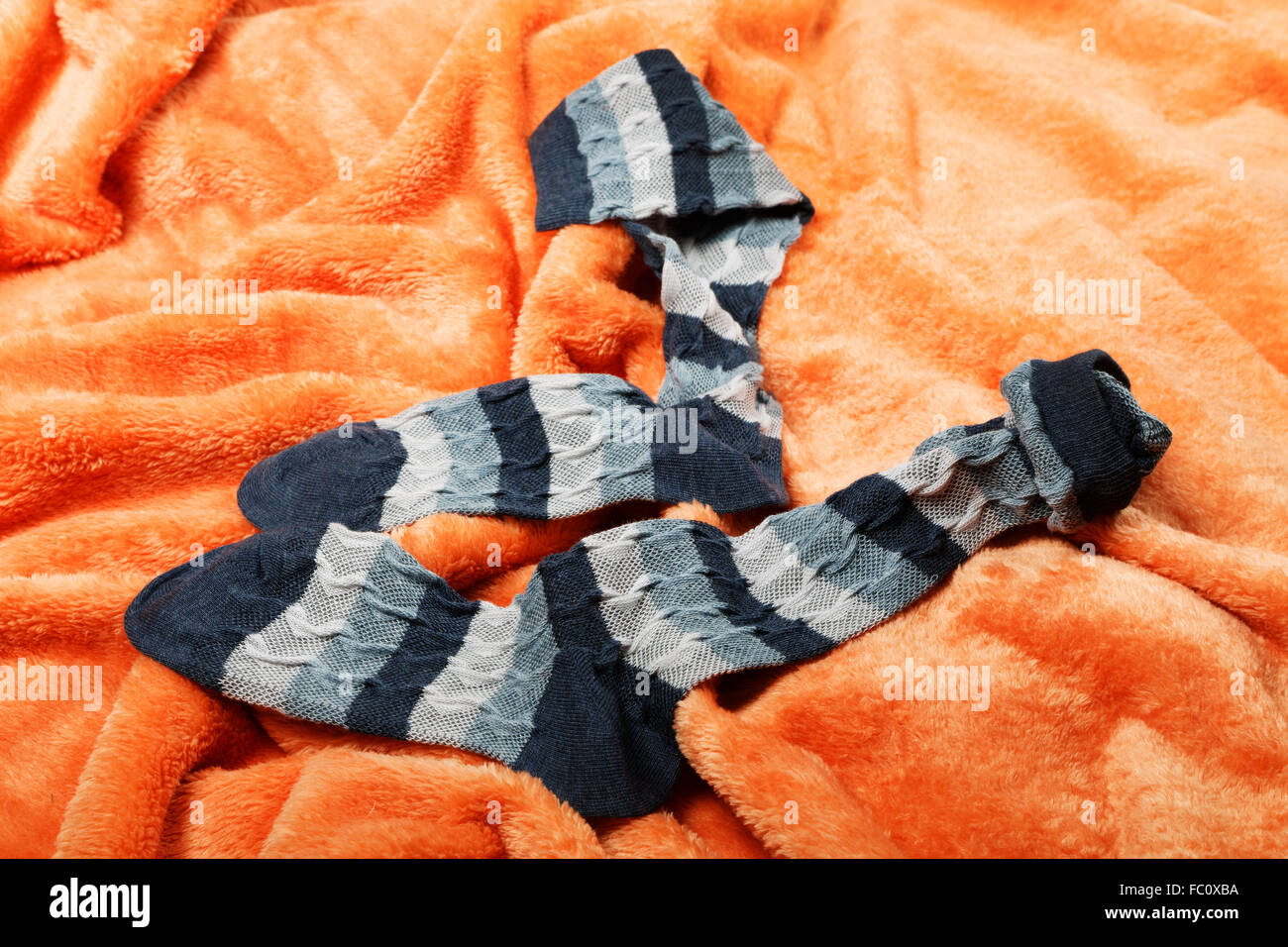Calcetines hembra en una manta naranja Foto de stock