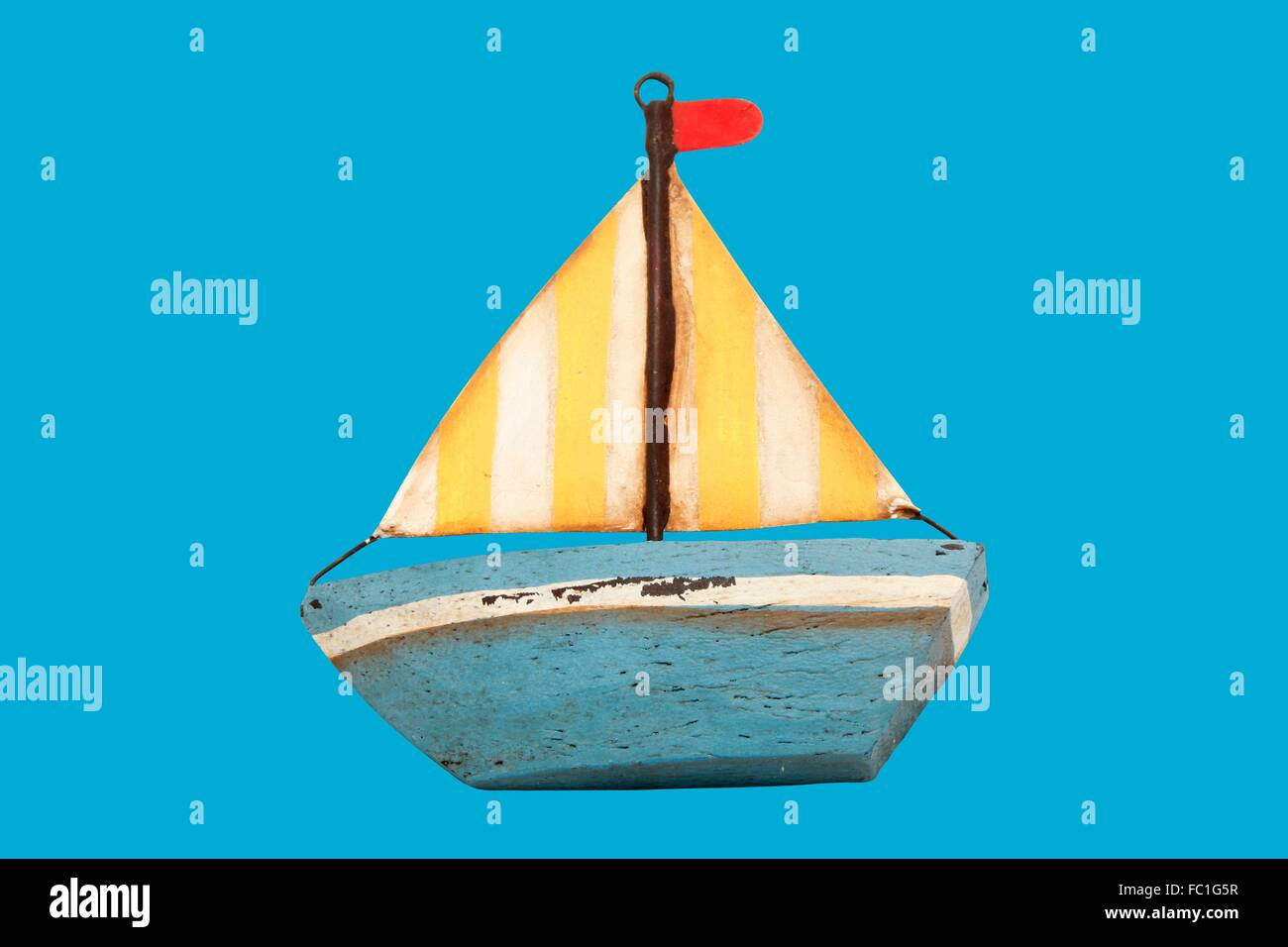 Viejo barco de juguete de madera aislado en azul Foto de stock