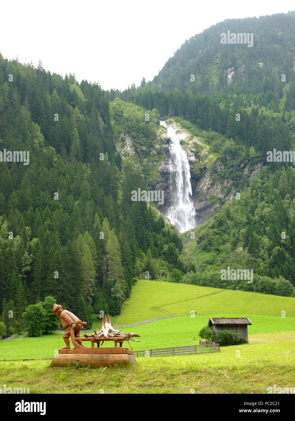 Cascada en la campiña Austriaca con cabaña y escultura en madera Fotografía  de stock - Alamy