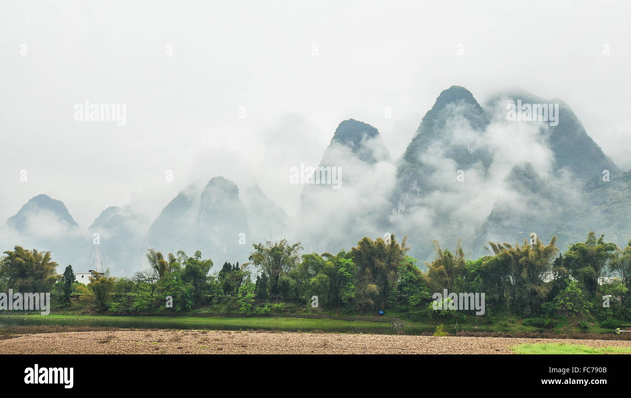 Las montañas de piedra caliza bajo las nubes bajas - Vista en crucero por el río Li, en Guilin, China Foto de stock