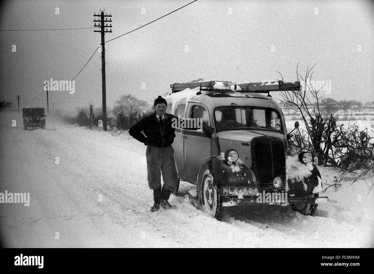 Electricista Ron Browne con Fordson van en nieve profunda en la carretera de salida de Shifnal Bridgnorth, Shropshire, Inglaterra, 1963. Foto de stock