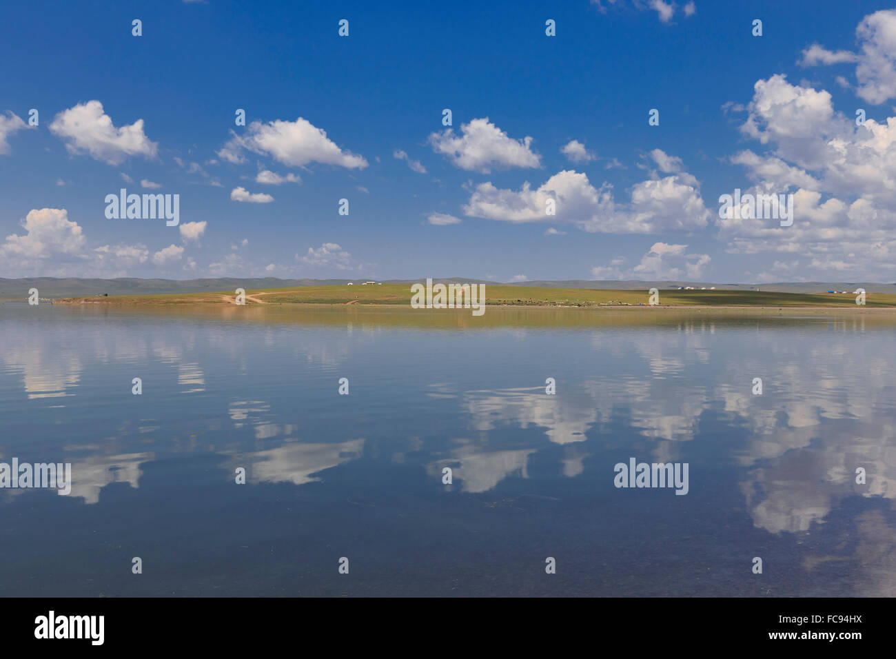 Esponjosas nubes en un cielo de verano azul, que se refleja en un lago, distante refleja gers, Arkhangai, Mongolia, Asia Central, África Foto de stock