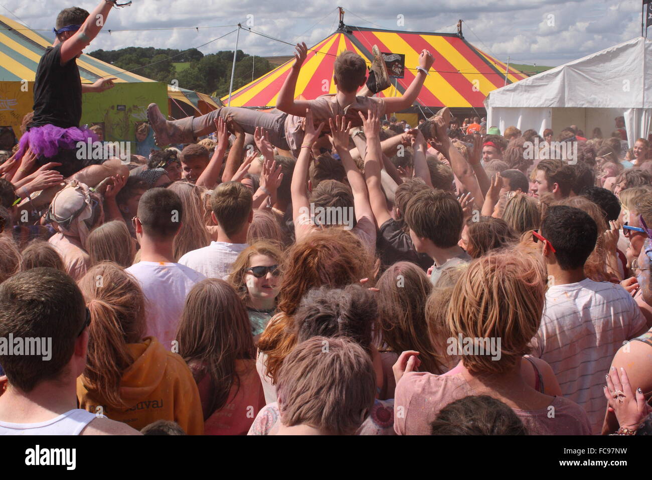 Un visitante del festival se lleva encima una multitud durante una pelea en la pintura de polvo y no music festival, Derbyshire, Reino Unido - Verano Foto de stock