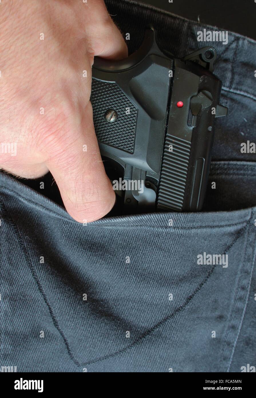 Pistola en un bolsillo del pantalón Foto de stock