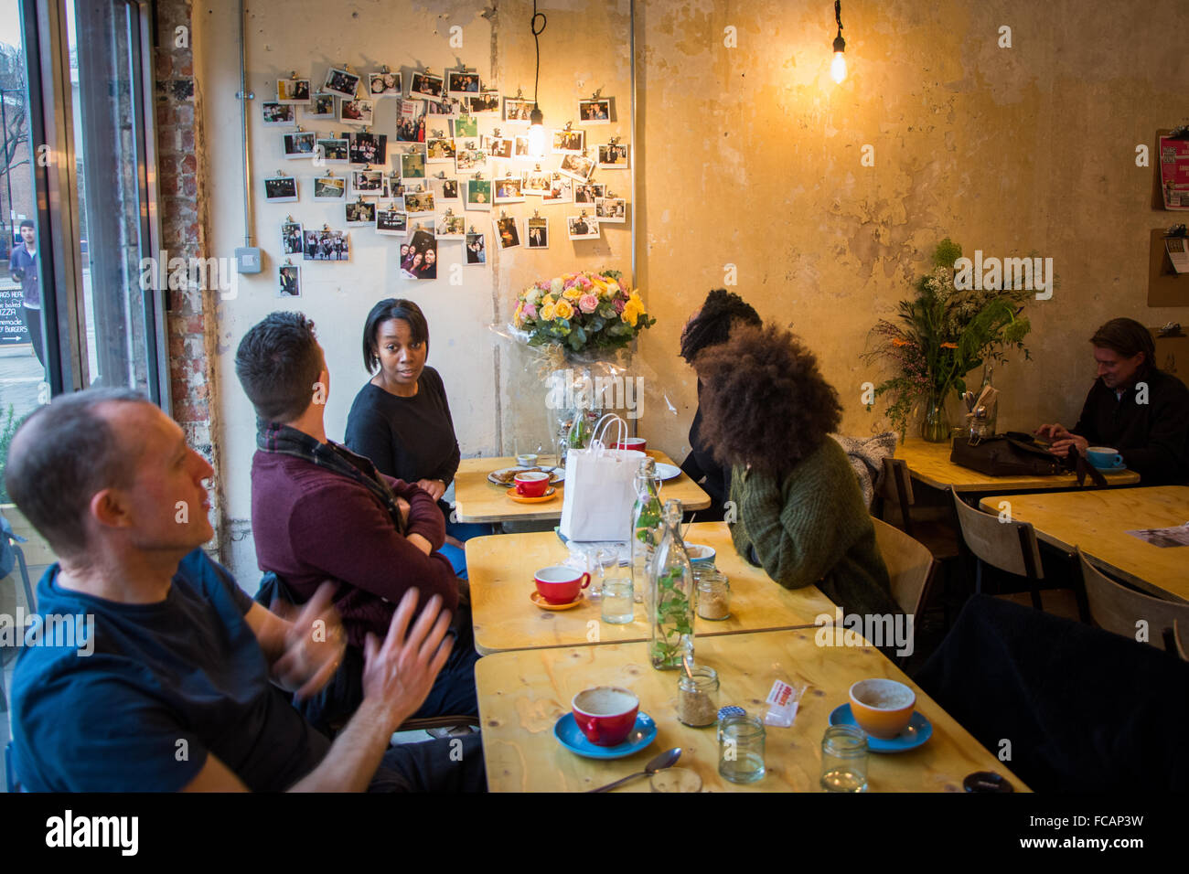 Los clientes a Russell Brand y comunidad Trew Era Café Foto de stock