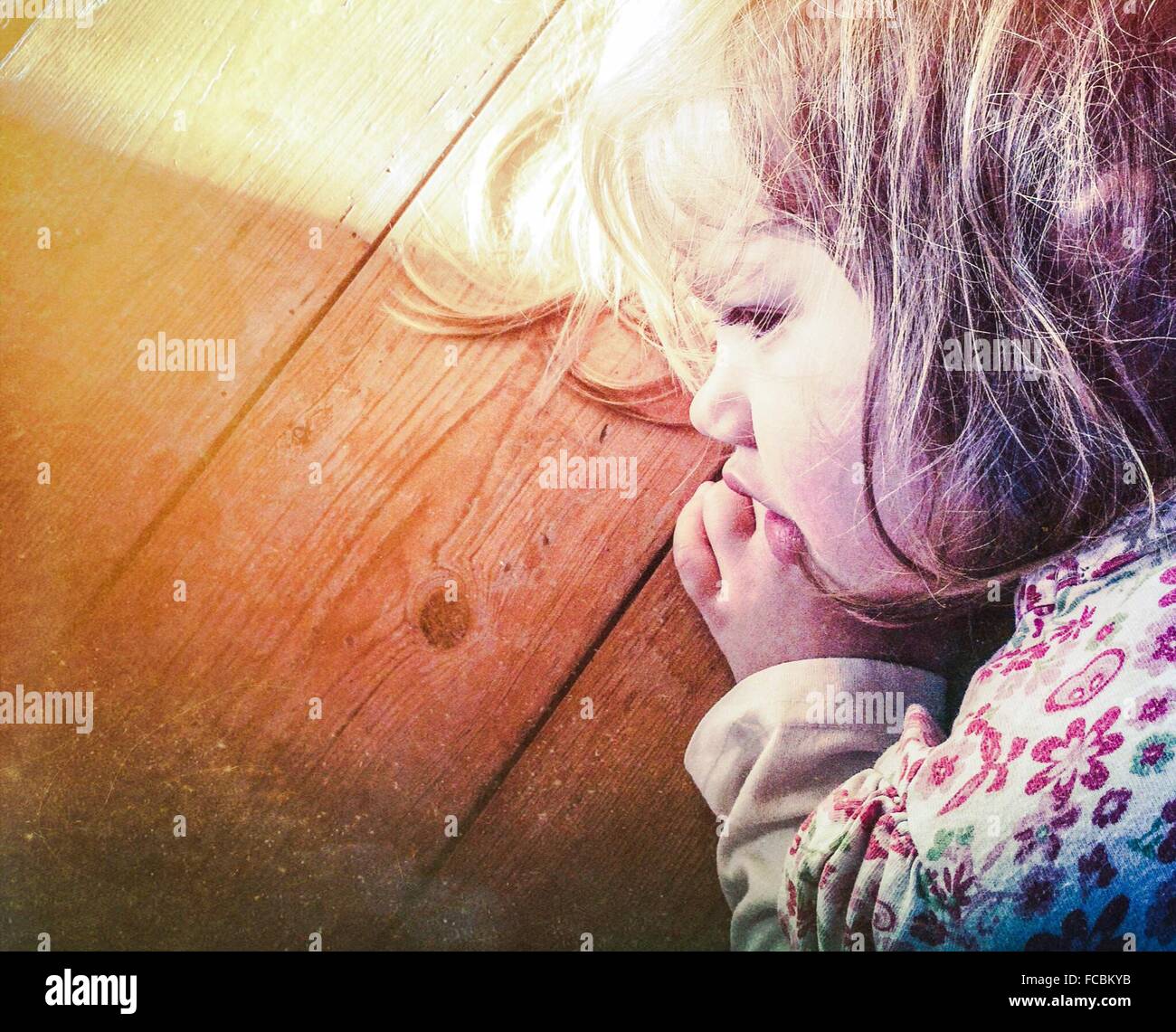 Primer plano de linda niña durmiendo en superficie de madera Foto de stock