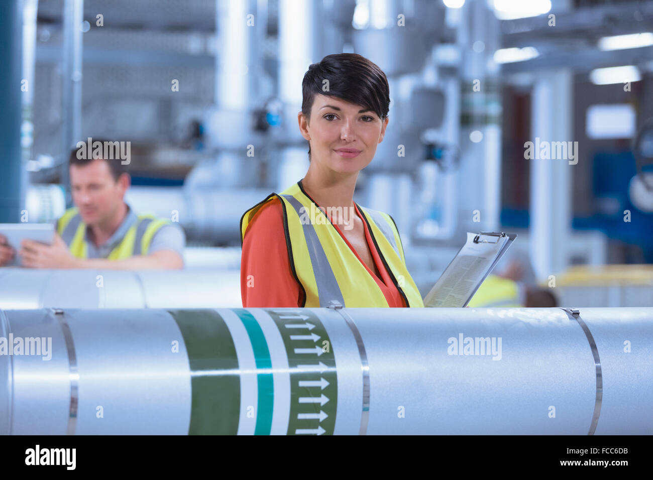 Retrato seguros trabajadora con el portapapeles en la fábrica. Foto de stock