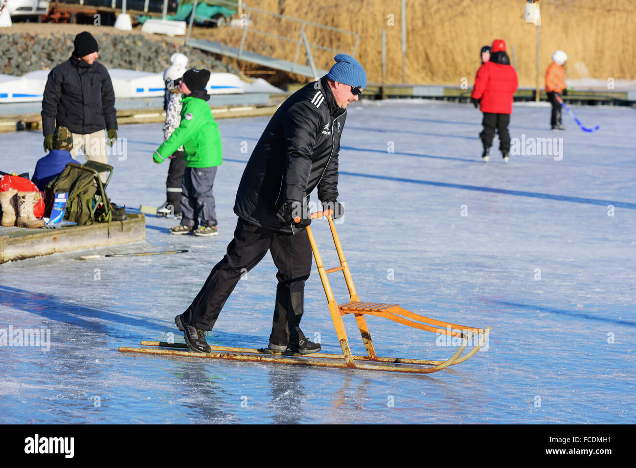 Listerby, Suecia - Enero 17, 2016: Desconocida macho adulto en el mar de hielo con un kicksled o chispa. Las personas activas havin diversión sobre hielo en b Foto de stock