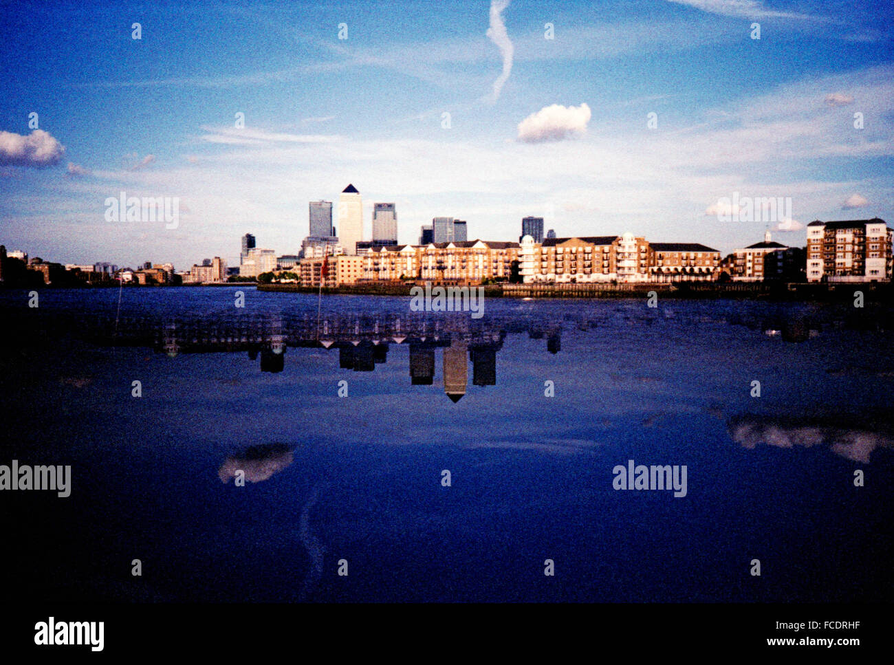 La reflexión de los edificios en aguas tranquilas contra el cielo azul Foto de stock