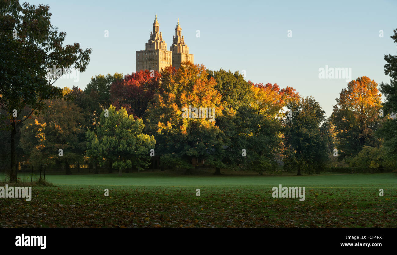 Central Park Sheep Meadow en pleno otoño colores con las torres de San Remo en la luz del amanecer. Otoño en Manhattan, Ciudad de Nueva York Foto de stock