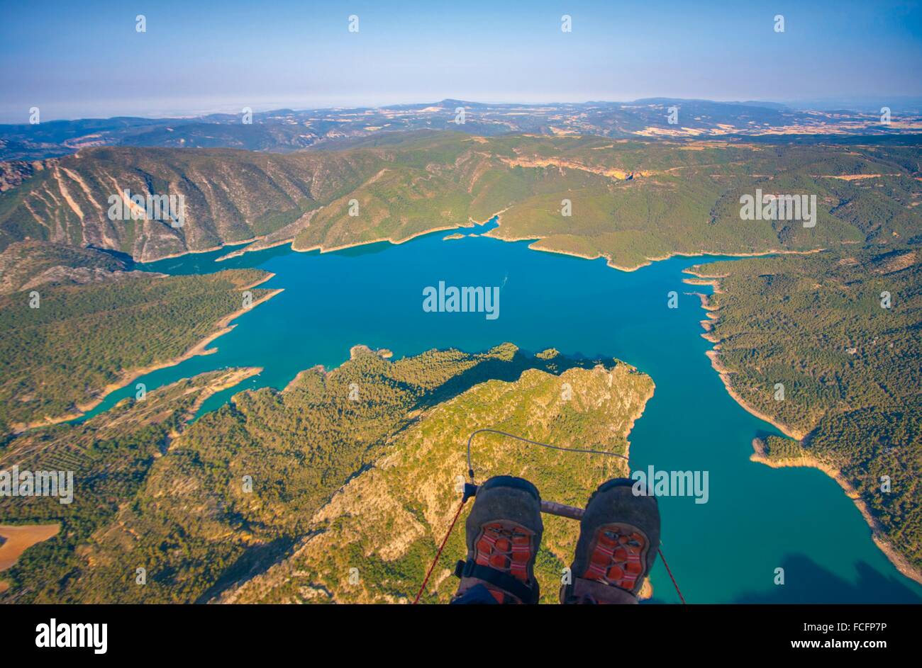 Vista aérea de un parapente sobrevolando el embalse de Canelles en las  montañas de Montec con sus botas en primer plano Fotografía de stock - Alamy