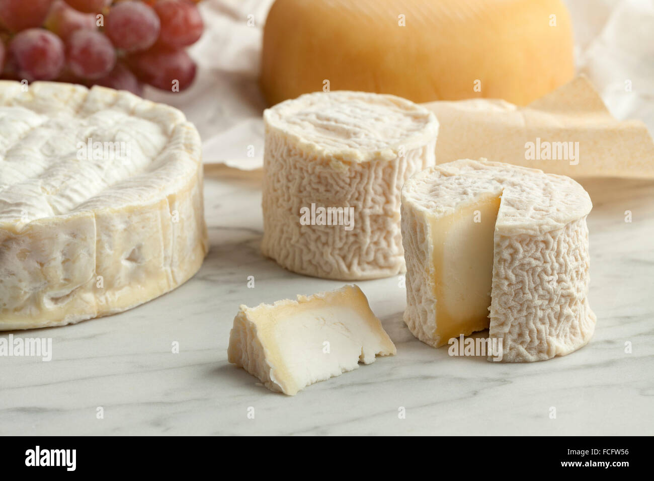 Tabla de quesos franceses con camembert, queso de cabra y las uvas como postre. Foto de stock
