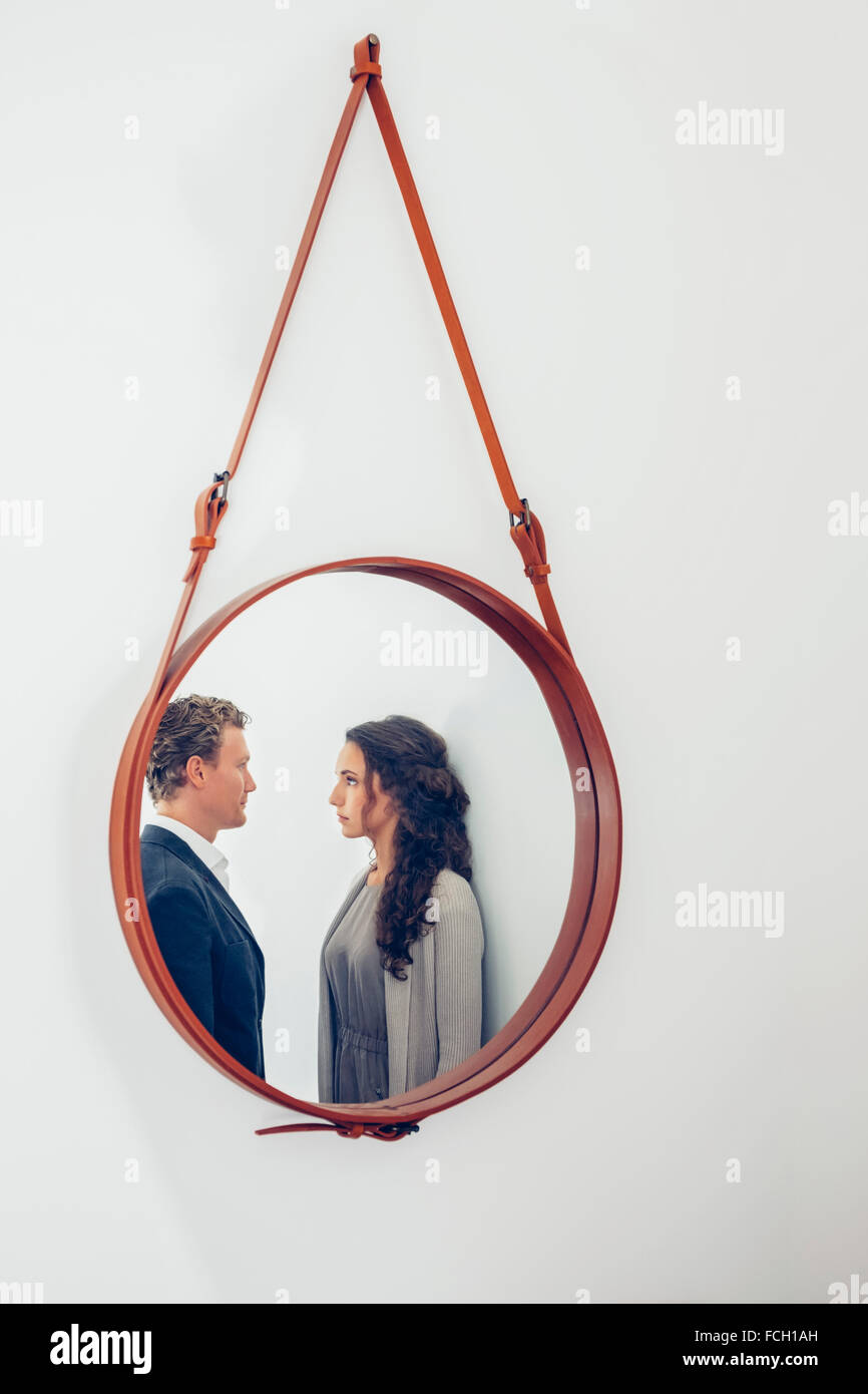 Reflejo de la pareja en un espejo colgado en la pared Fotografía de stock -  Alamy