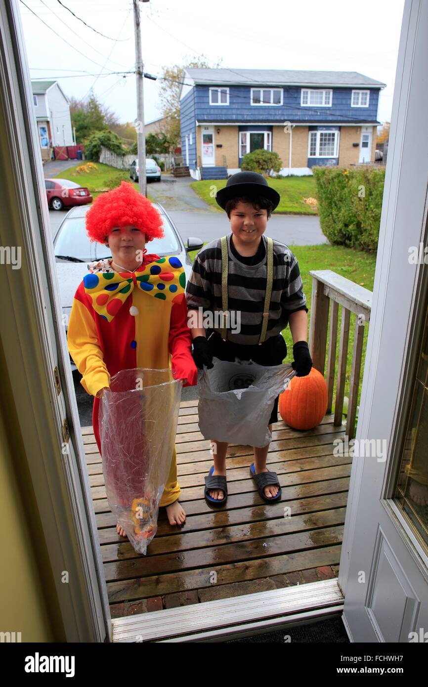 Dos muchachos vestidos en disfraces de Halloween en la puerta de una casa  waoting para golosinas o dulces Fotografía de stock - Alamy