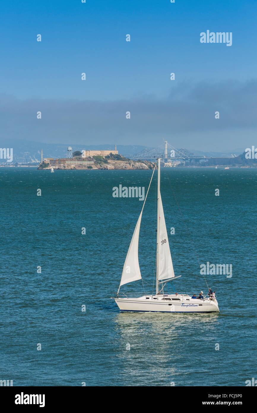 Velero en la Bahía de San Francisco con prisión de Alcatraz en el fondo, California, EE.UU. Foto de stock
