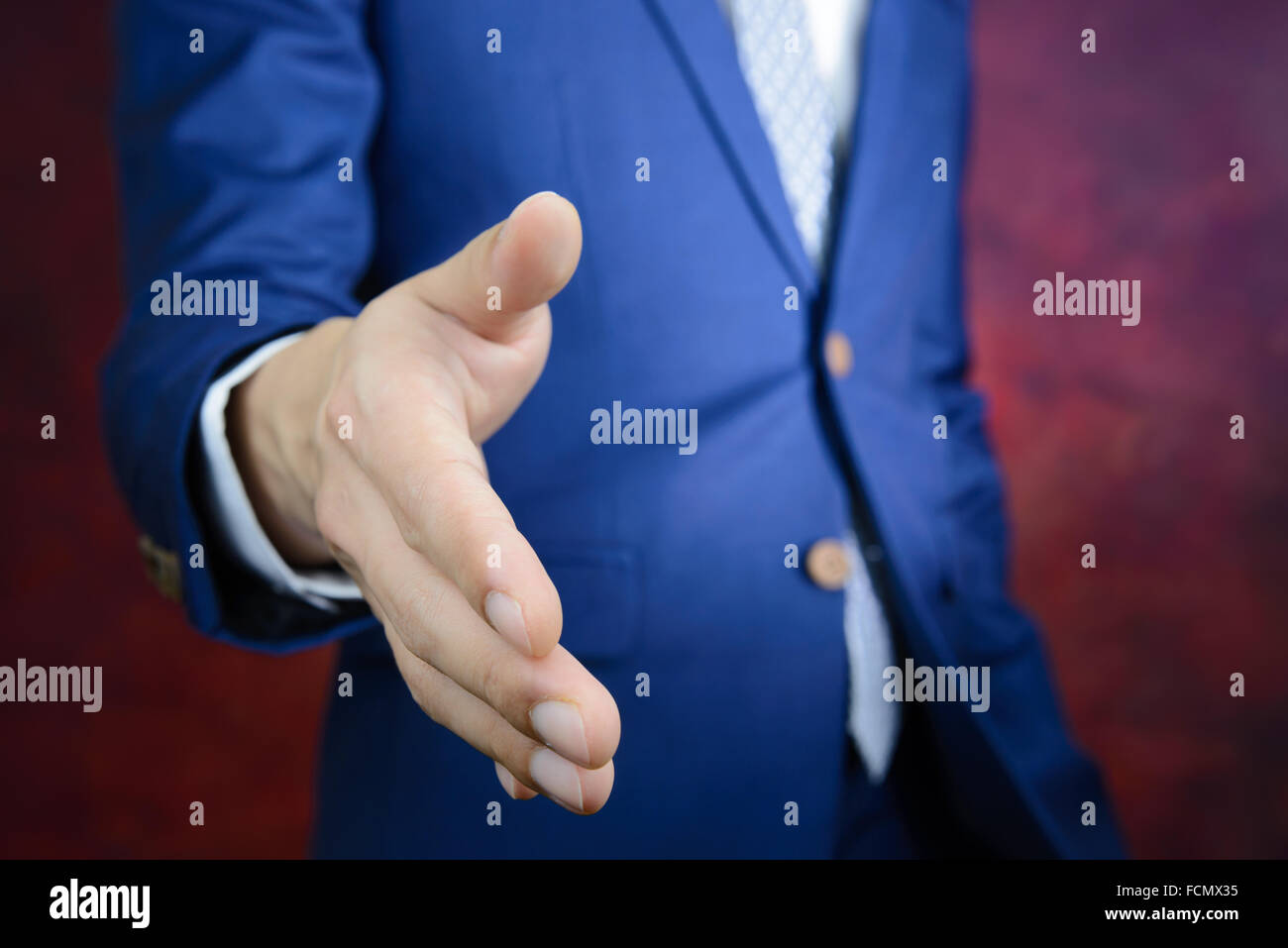 Empresario de traje azul llegando a mano para agitar las manos, hacer un negocio concepto Foto de stock