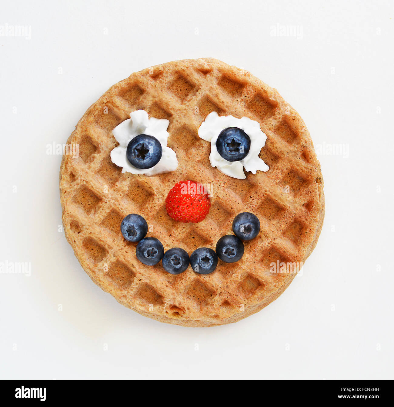 Waffle con una cara feliz hechas de frutas Foto de stock