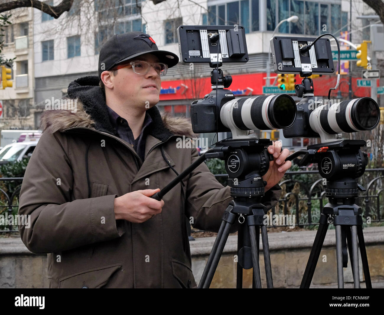 Un hombre haciendo una película con dos cámaras Canon. En Union Square Park, en la Ciudad de Nueva York. Foto de stock