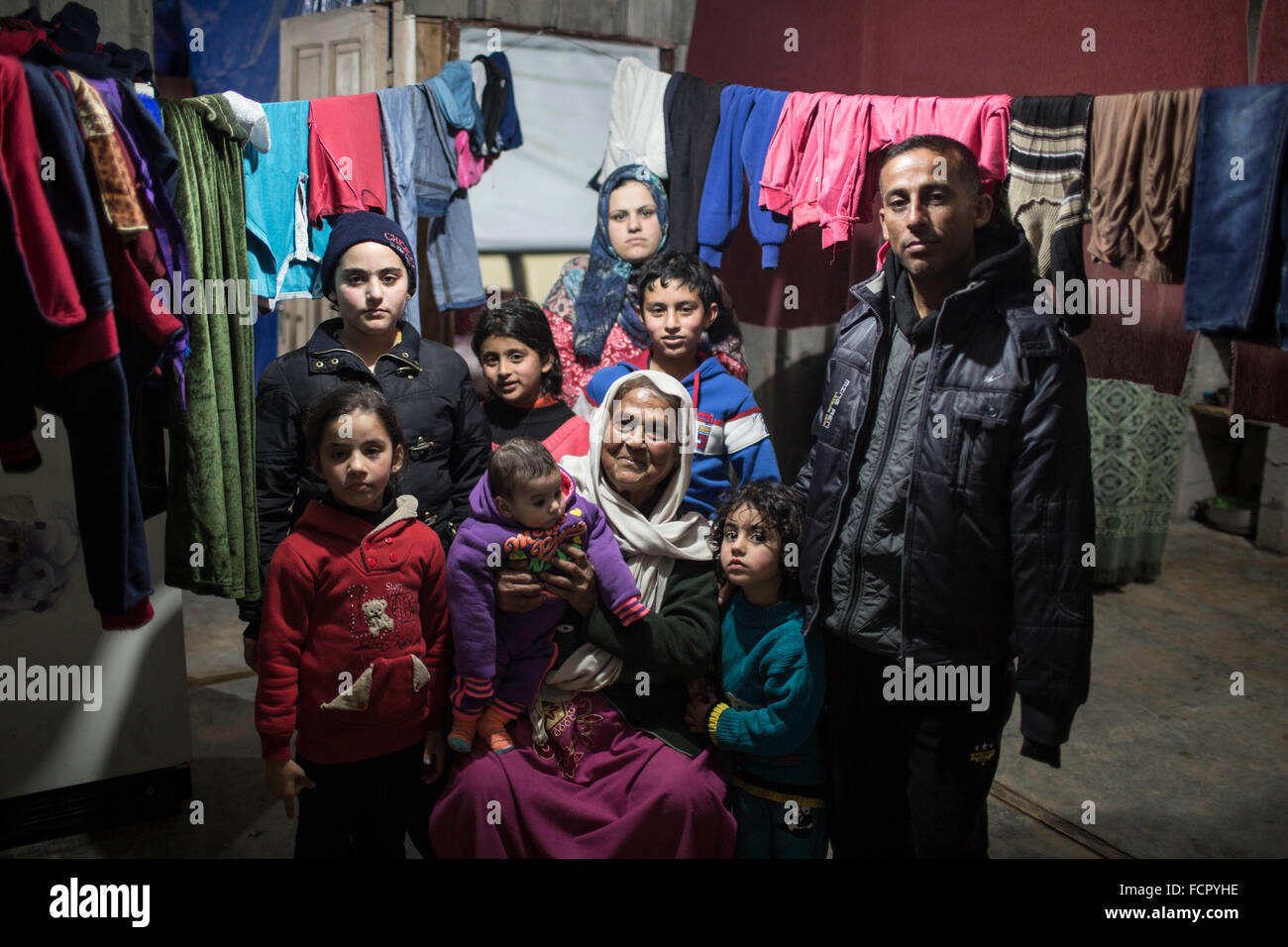 Gaza, la franja de Gaza. 23 ene, 2016. Soad palestino Qassem, 72, (C) y a los miembros de su familia posan para una foto en su vivienda temporal en frente de su casa destruida, que fue dañado durante la guerra israelí contra la Franja de Gaza en el verano de 2014, en la ciudad de Beit Hanoun, en el norte de la Franja de Gaza, el 23 de enero, 2016. © Wissam Nassar/Xinhua/Alamy Live News Foto de stock