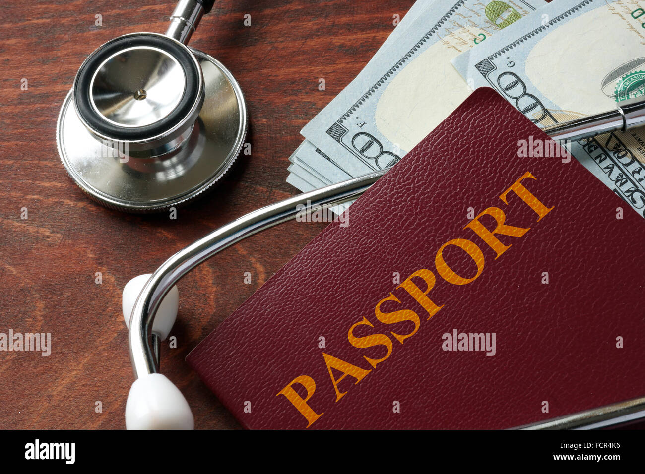 Estetoscopio con pasaporte y billetes de dólar. Concepto de turismo medico. Foto de stock