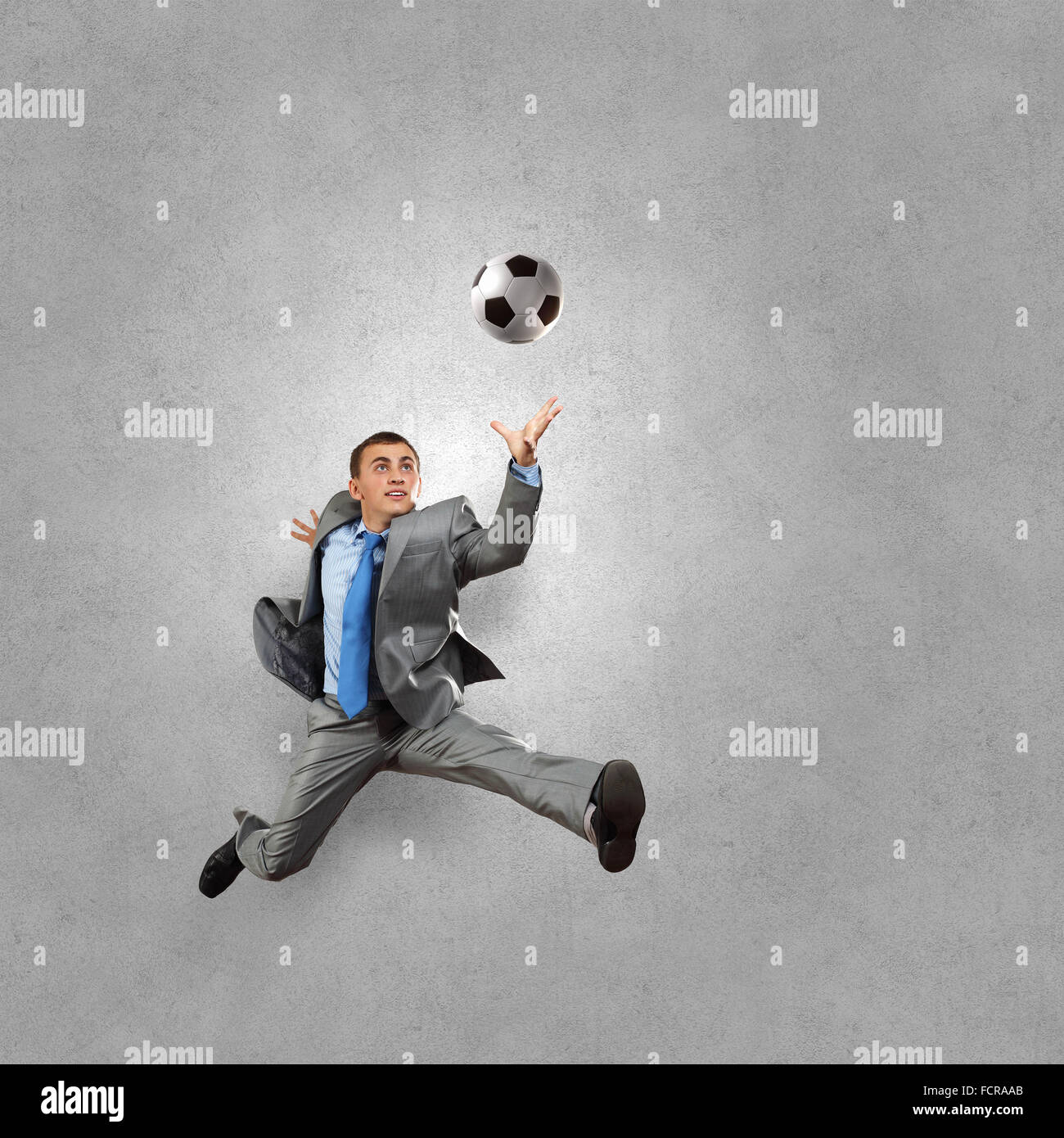 Traje de empresario a atrapar la pelota de fútbol en salta Fotografía de  stock - Alamy
