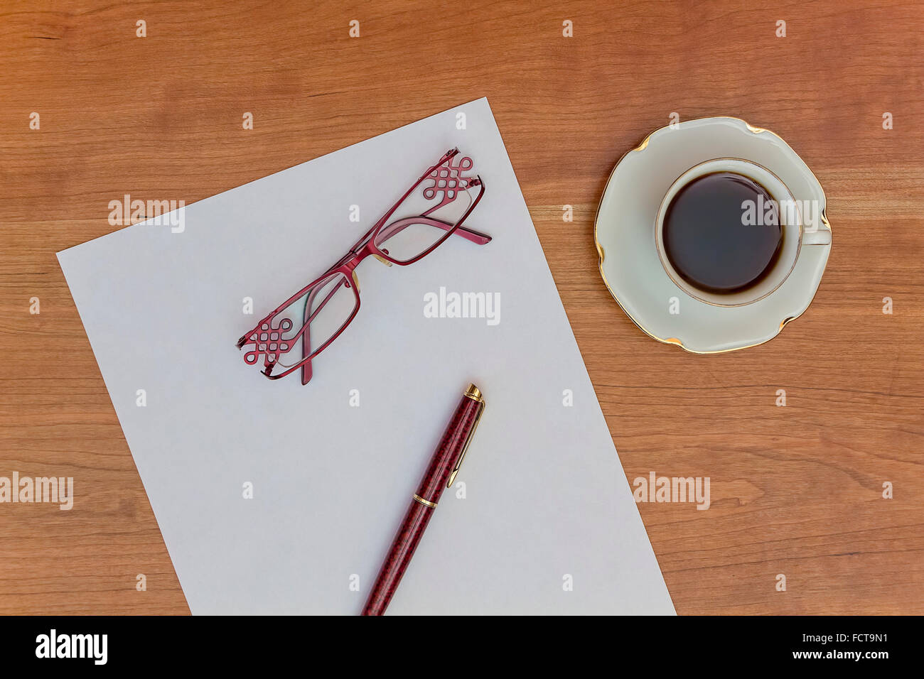 El papeleo de oficina. Escritorio en la oficina con papel, lápiz, gafas y café. Foto de stock