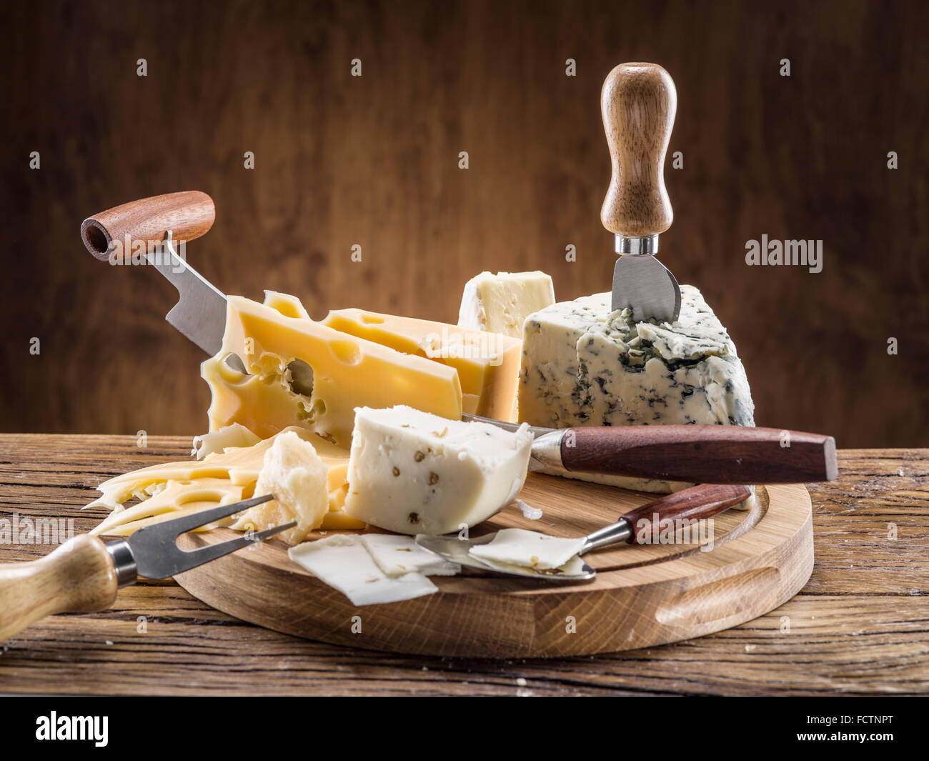 Variedad de quesos sobre una tabla de madera. Foto de stock