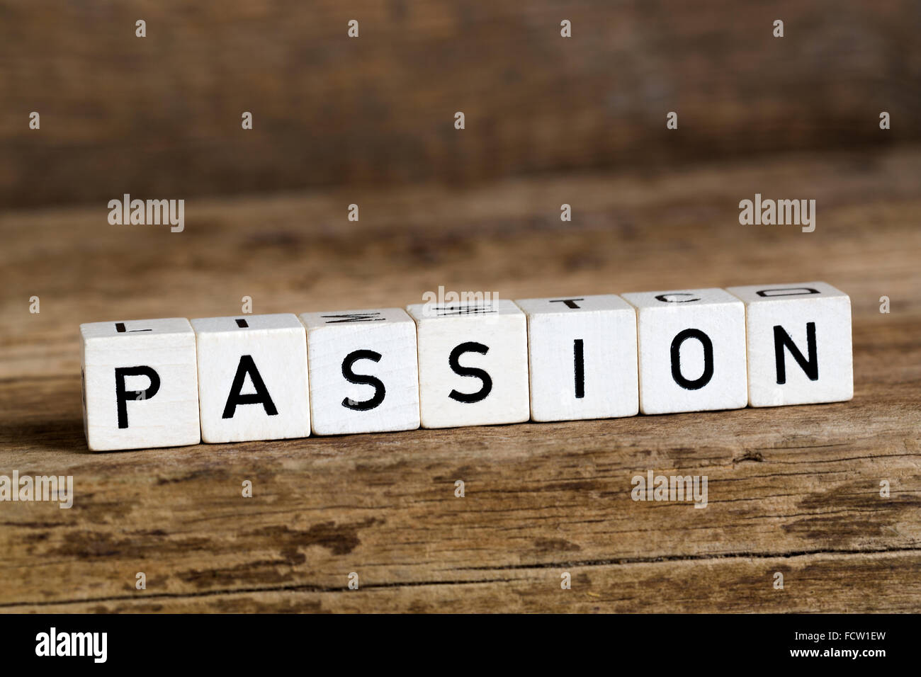 La palabra pasión escrita en cubos sobre fondo de madera Foto de stock