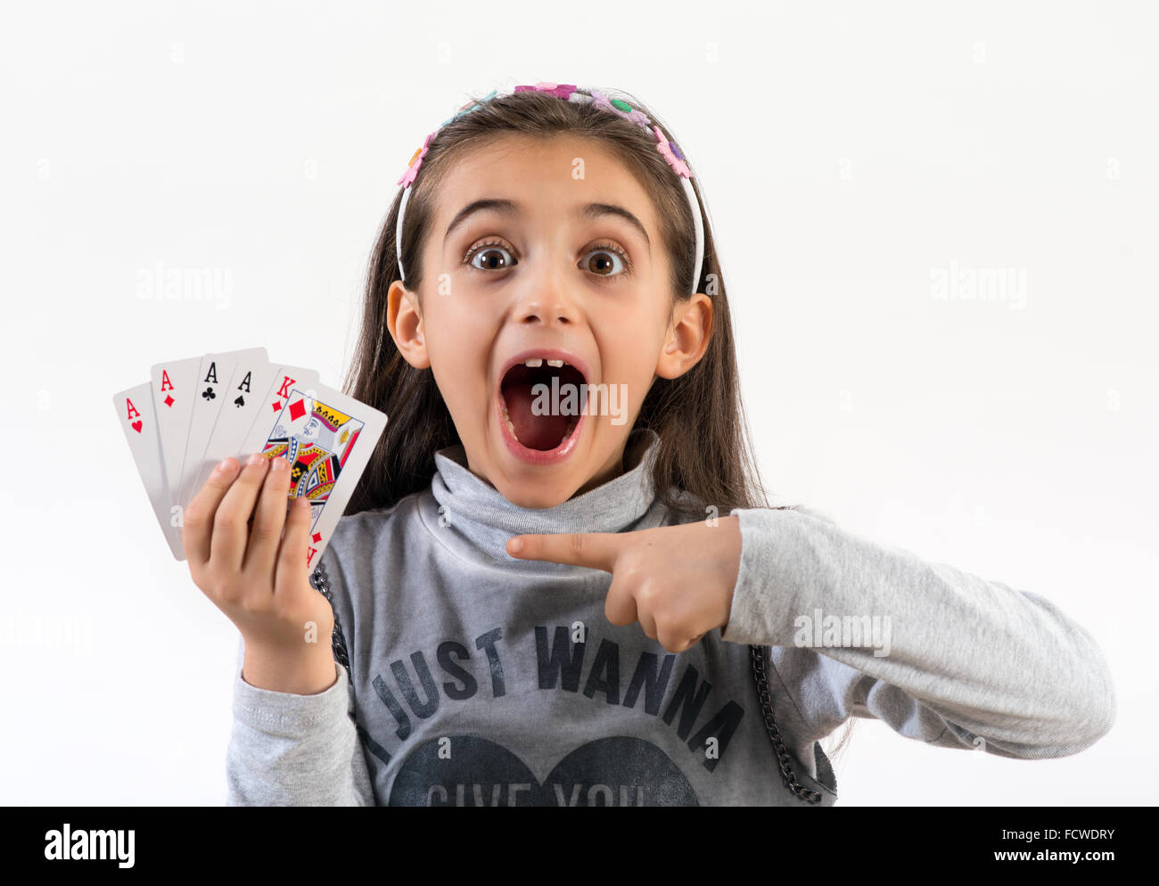 Emocionada niña señalando una mano de póquer ganadora Foto de stock