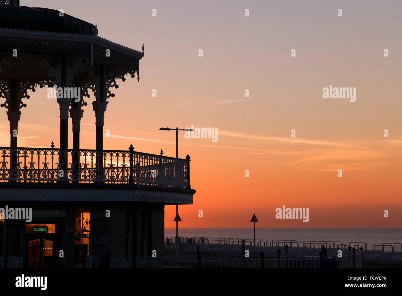 Brighton's Victorian bandstand siluetas contra el cielo del amanecer rojo Foto de stock