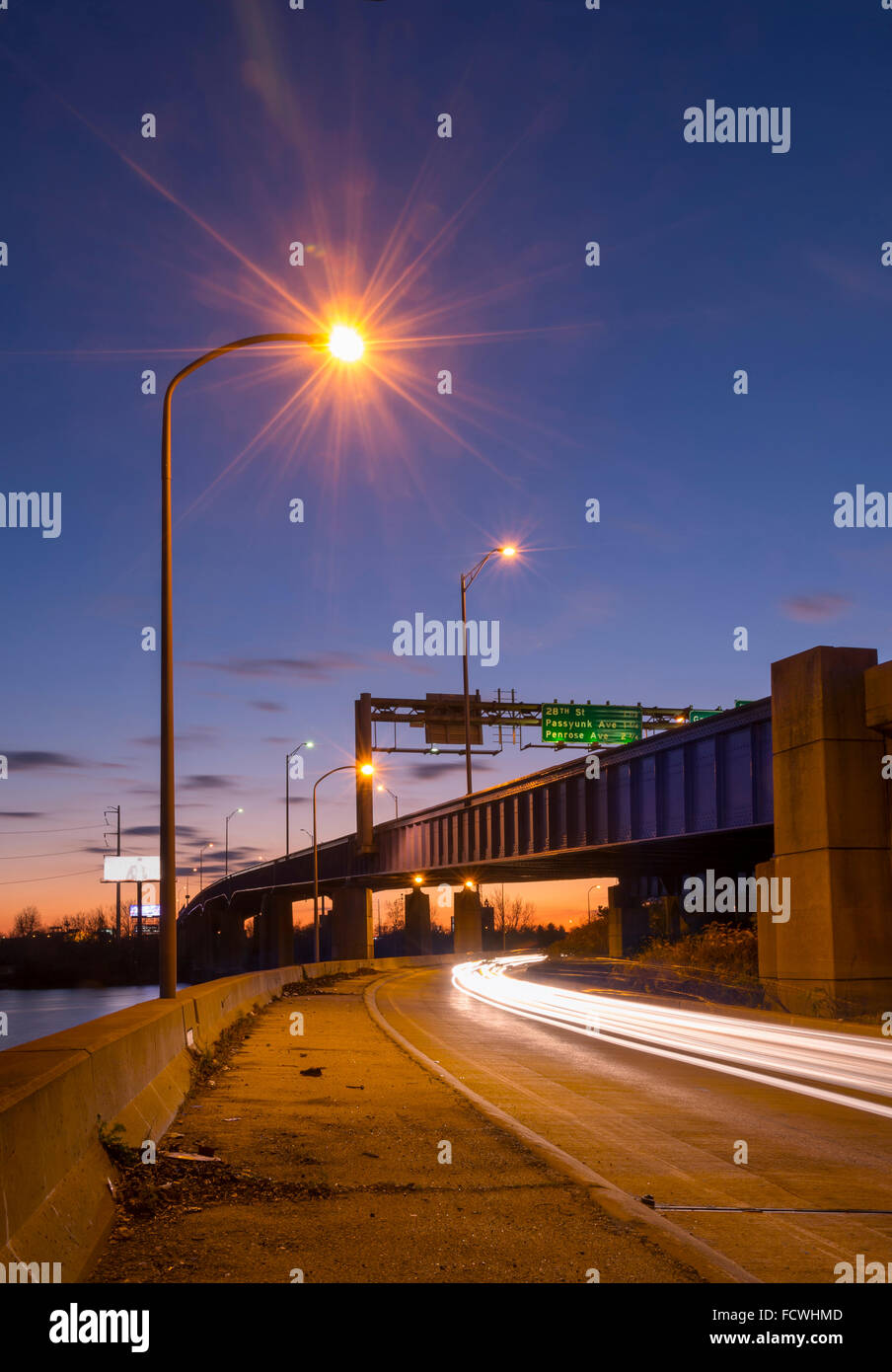 La autopista y el puente al atardecer con las luces de la calle, Filadelfia, Pensilvania, EE.UU. Foto de stock