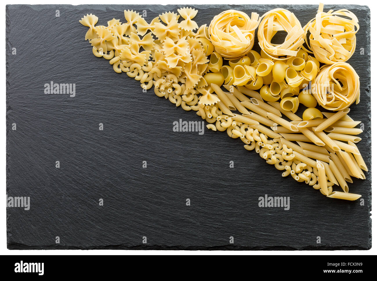 Variedad de tipos y formas de pasta italiana sobre un fondo de piedra oscura. Foto de stock
