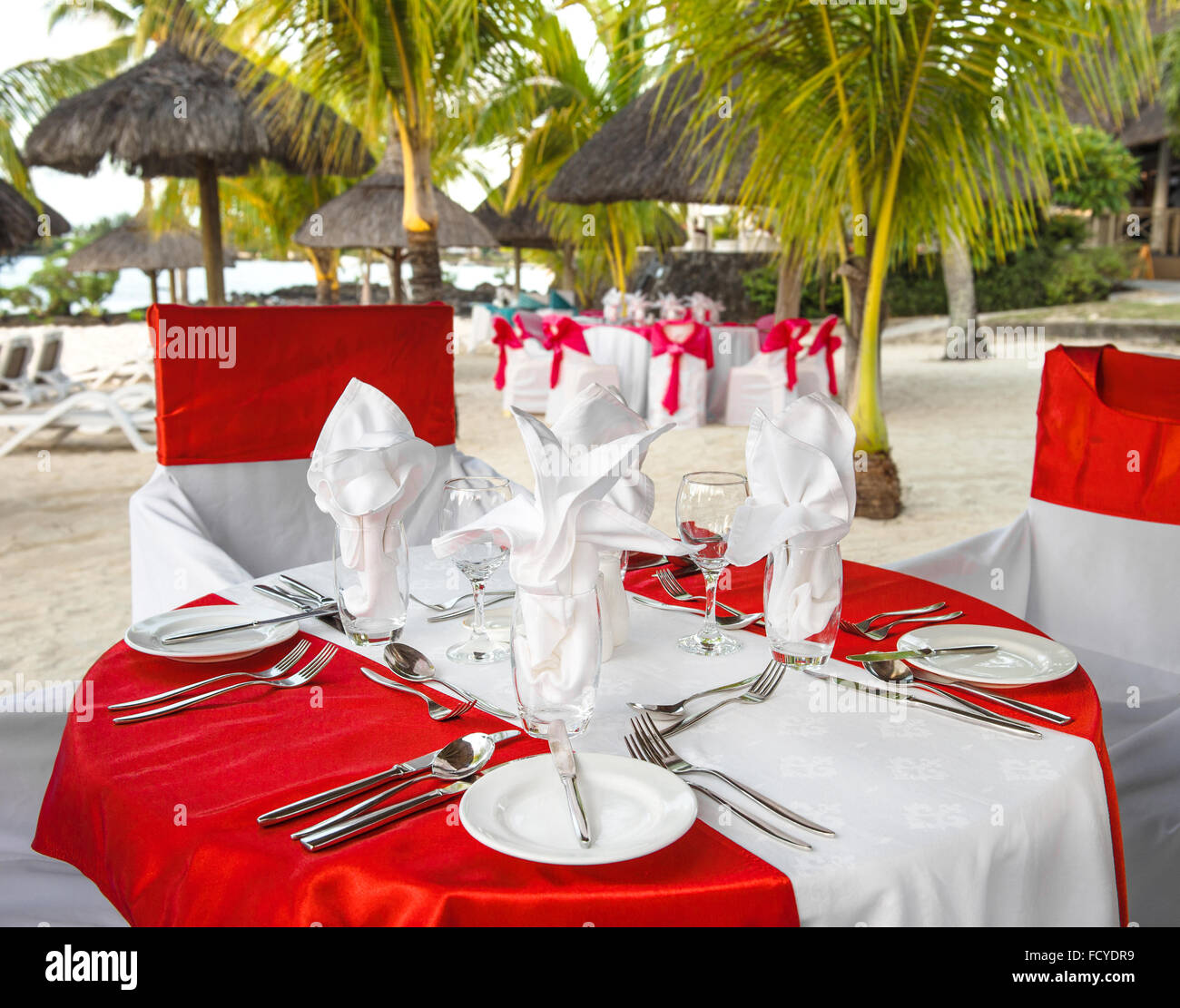 Cena romántica en la playa Sunset. Roja de la mesa festiva place setting. Enfoque selectivo Foto de stock