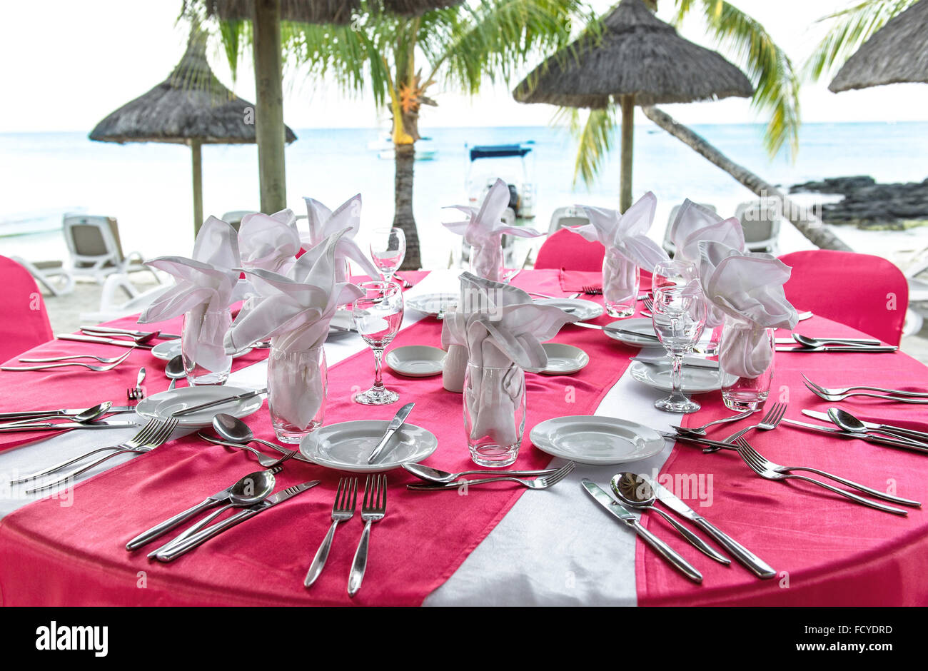 Cena romántica en la playa Sunset. Tabla rosa festiva place setting. Enfoque selectivo Foto de stock