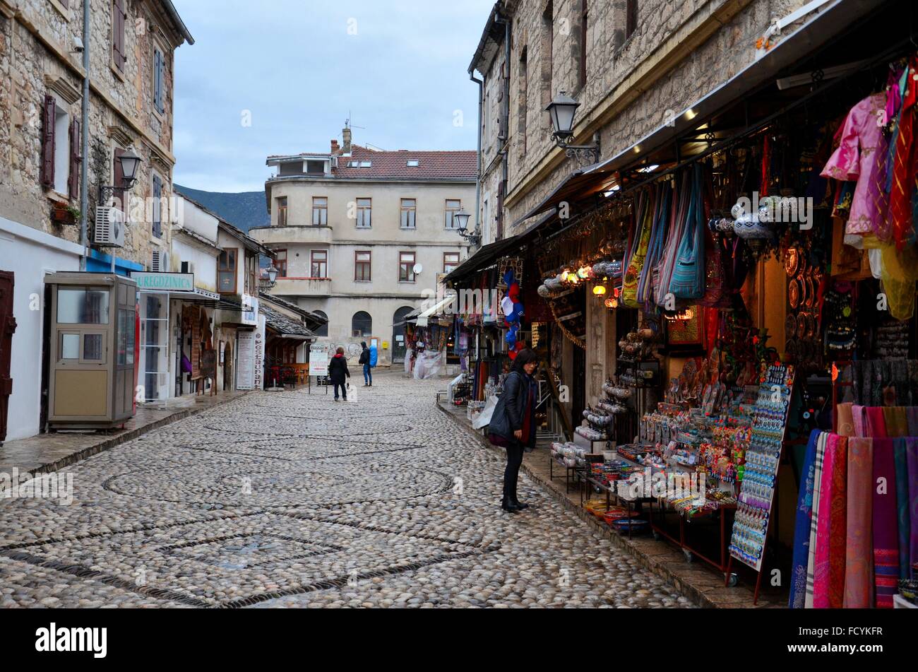 Empedrada calle turística con tienda de souvenirs y ropa medieval en la  ciudad de Mostar en Bosnia Herzegovina Fotografía de stock - Alamy