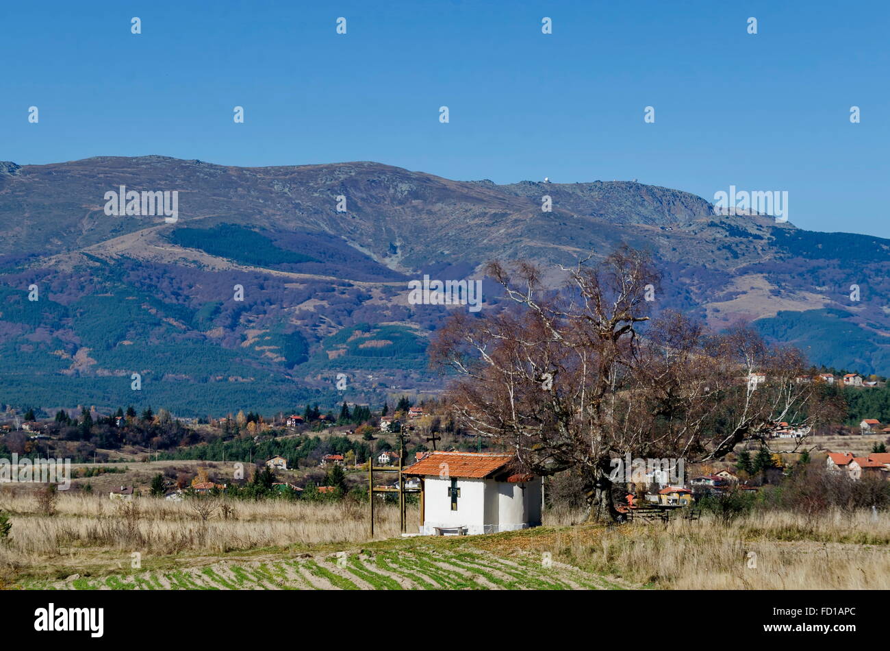 Vista a distancia de la capilla 'Saint Cipriano' en Plana montaña. A la distancia la montaña Vitosha vista, Bulgaria Foto de stock