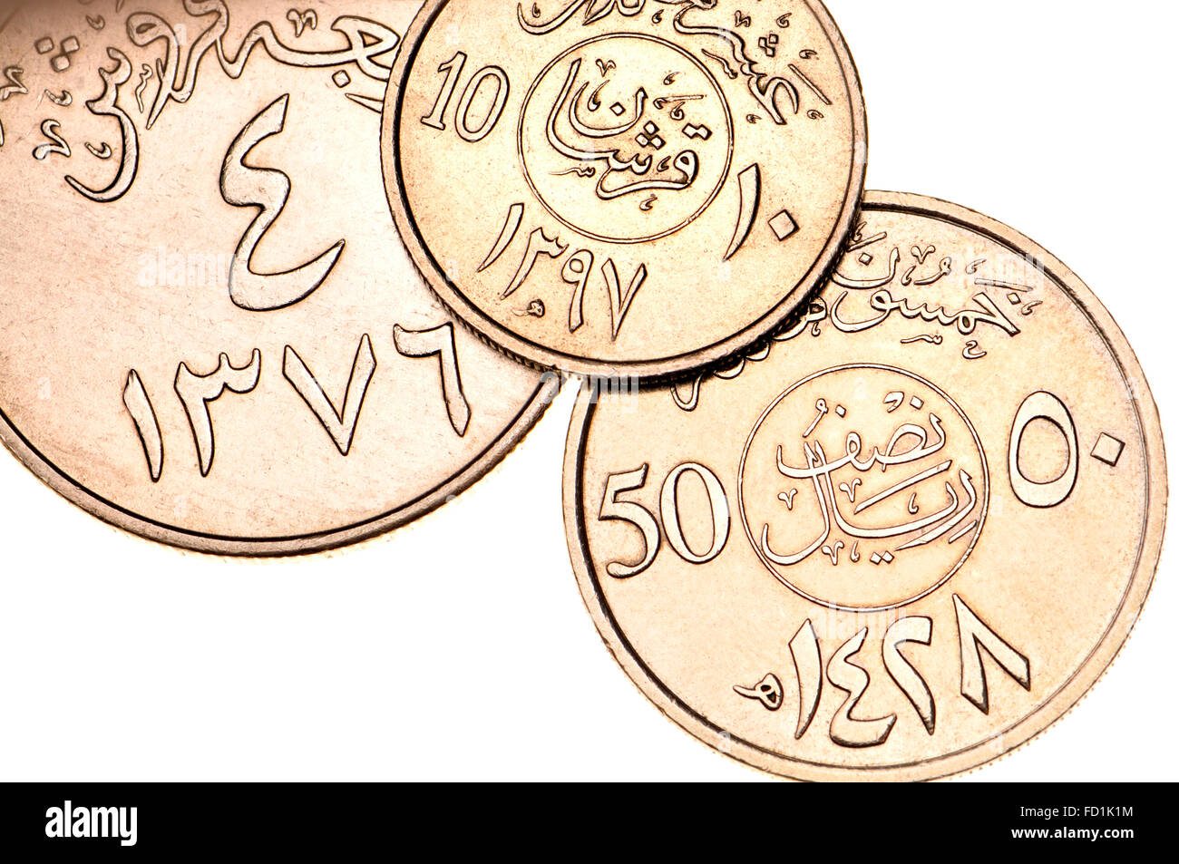 Las monedas de Arabia Saudita mostrando escritura árabe y símbolos en el alfabeto árabe oriental y las fechas en el calendario islámico Foto de stock
